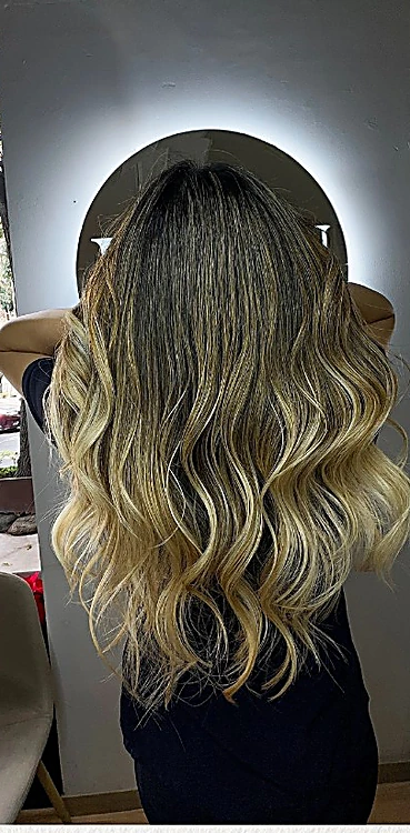 Balayage largo en tonos rubios con ondas, visto de espaldas